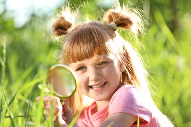 Little girl exploring plant outdoors. Summer camp