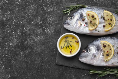 Photo of Fresh dorado fish and ingredients on black table, flat lay. Space for text