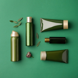 Flat lay composition with cosmetic products on green background