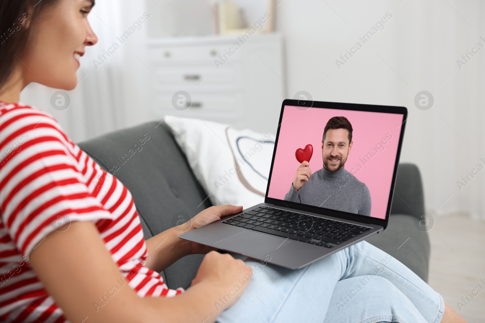 Image of Long distance love. Woman having video chat with her boyfriend via laptop at home, closeup