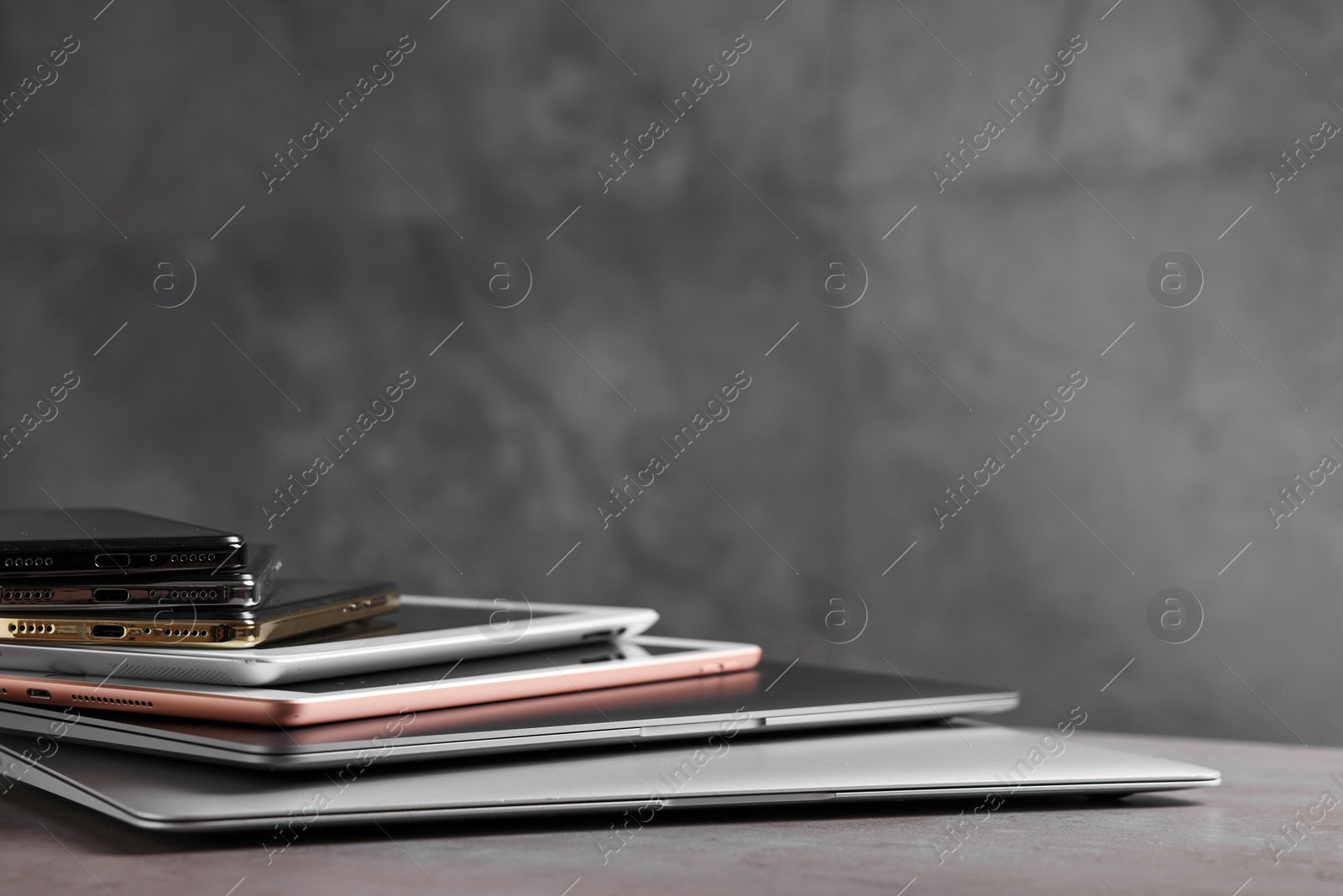 Photo of Many different modern gadgets on grey table, closeup. Space for text