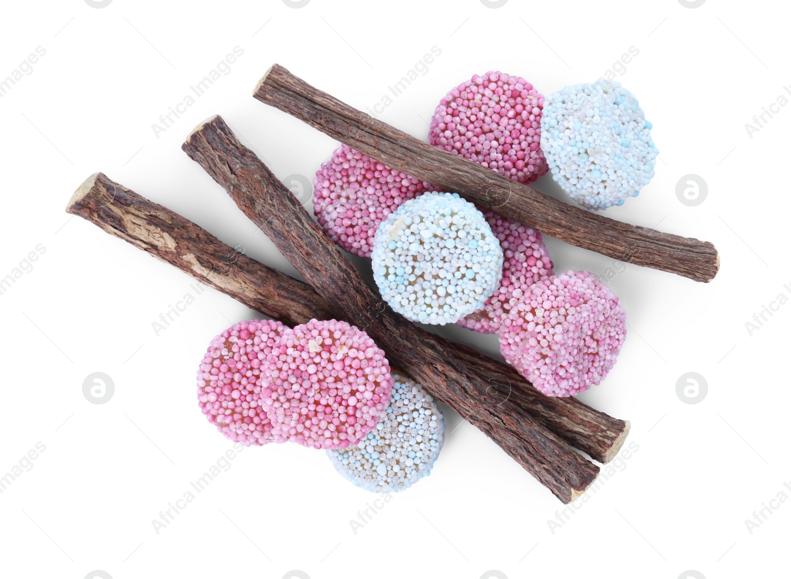 Photo of Many tasty candies and dried sticks of liquorice root isolated on white, top view