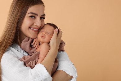 Photo of Mother with her cute newborn baby on beige background. Space for text