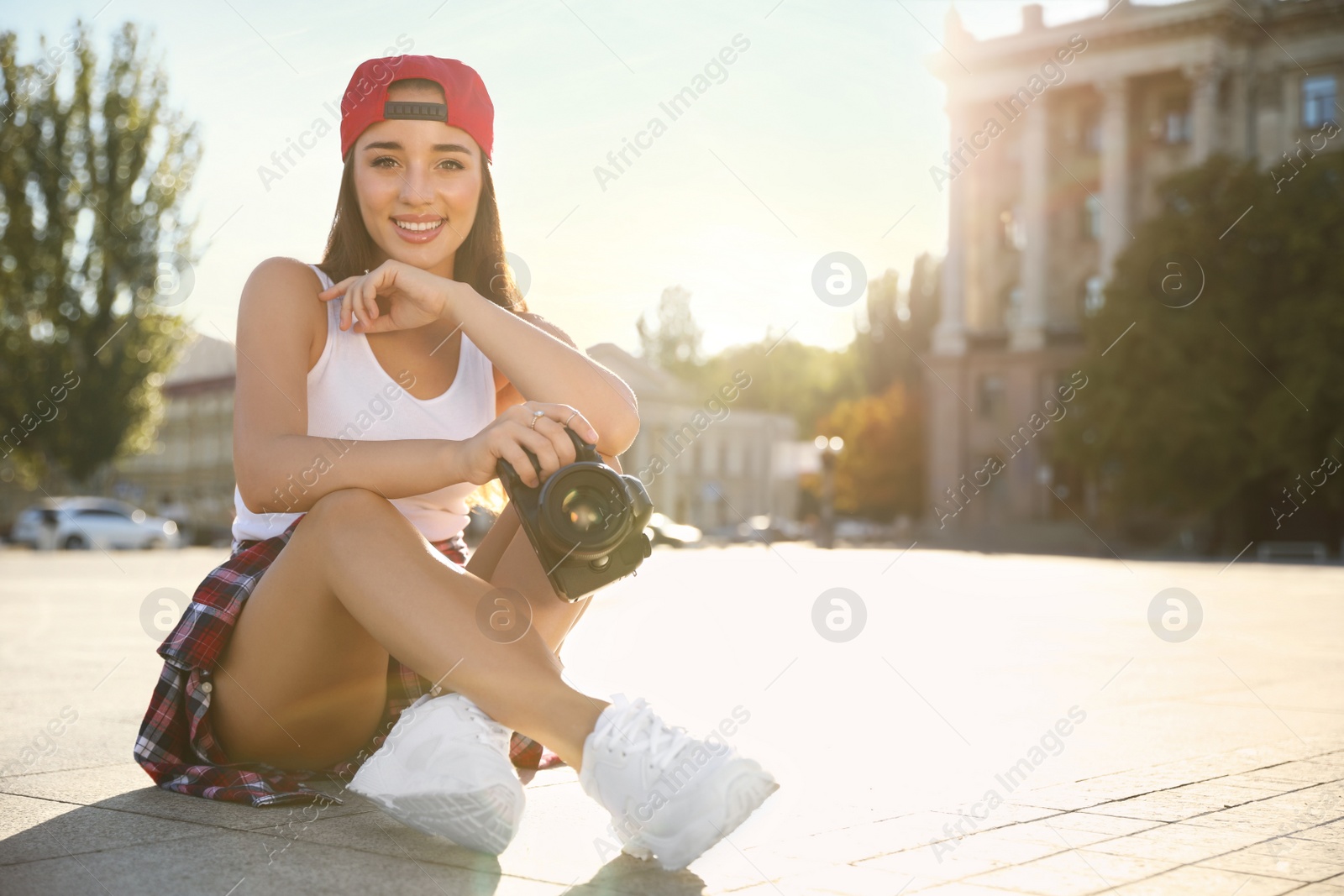 Photo of Young photographer with professional camera outdoors. Space for text