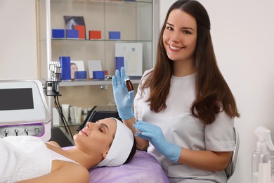 Photo of Young woman undergoing cosmetic procedure in beauty salon