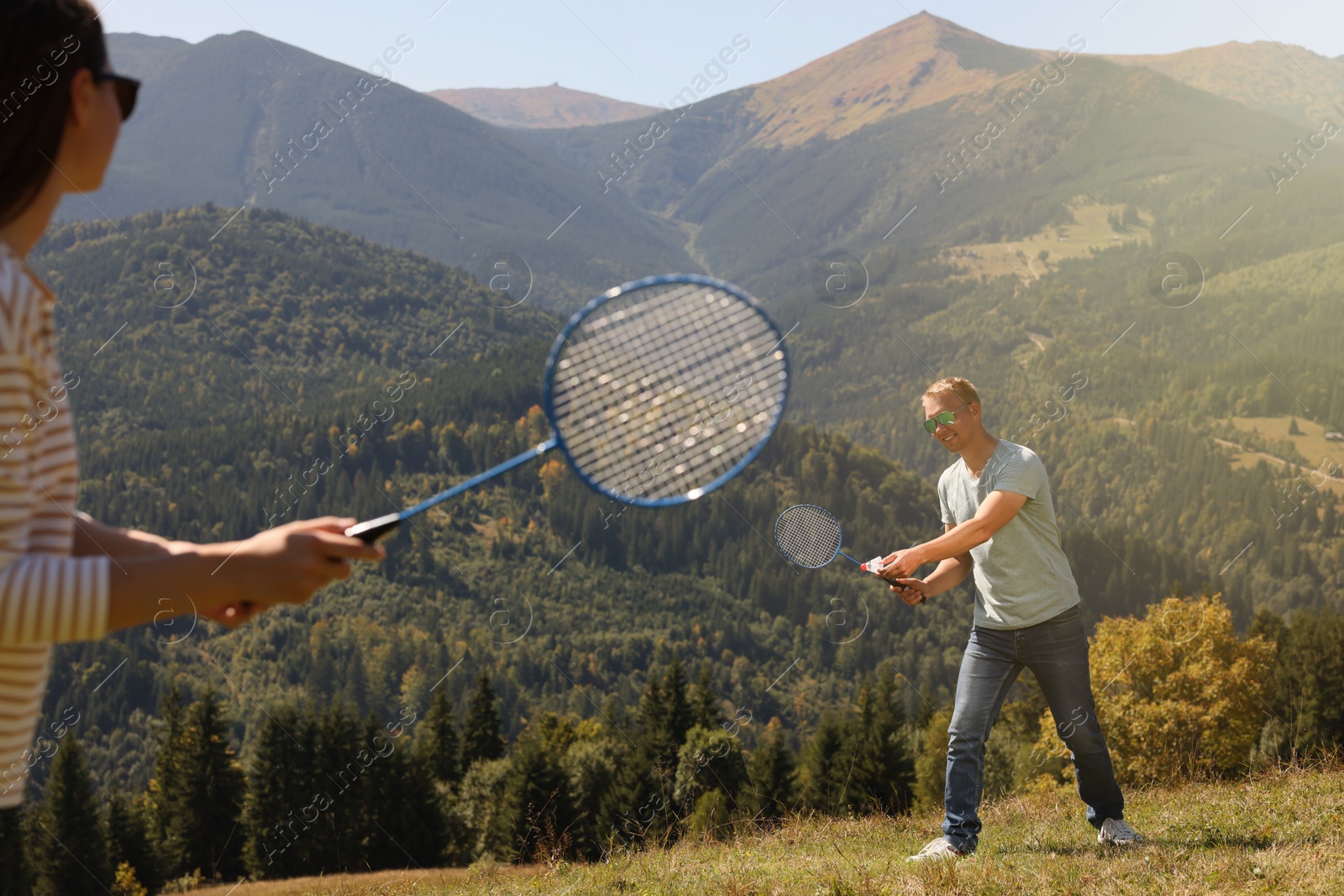 Photo of Couple playing badminton in mountains on sunny day