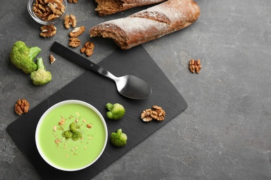 Photo of Flat lay composition with bowl of broccoli cream soup on grey table, space for text