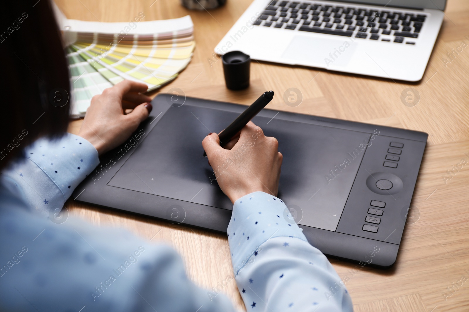 Photo of Professional designer with graphic tablet at wooden table, closeup