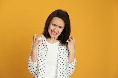 Photo of Portrait of angry woman on yellow background. Hate concept