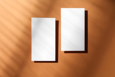 Photo of Empty business card on light brown background, top view. Mockup for design