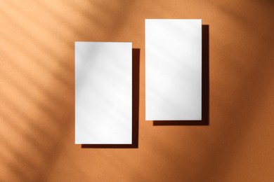 Empty business card on light brown background, top view. Mockup for design