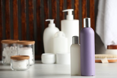 Photo of Shampoo, conditioner and toiletries on white table indoors, space for text