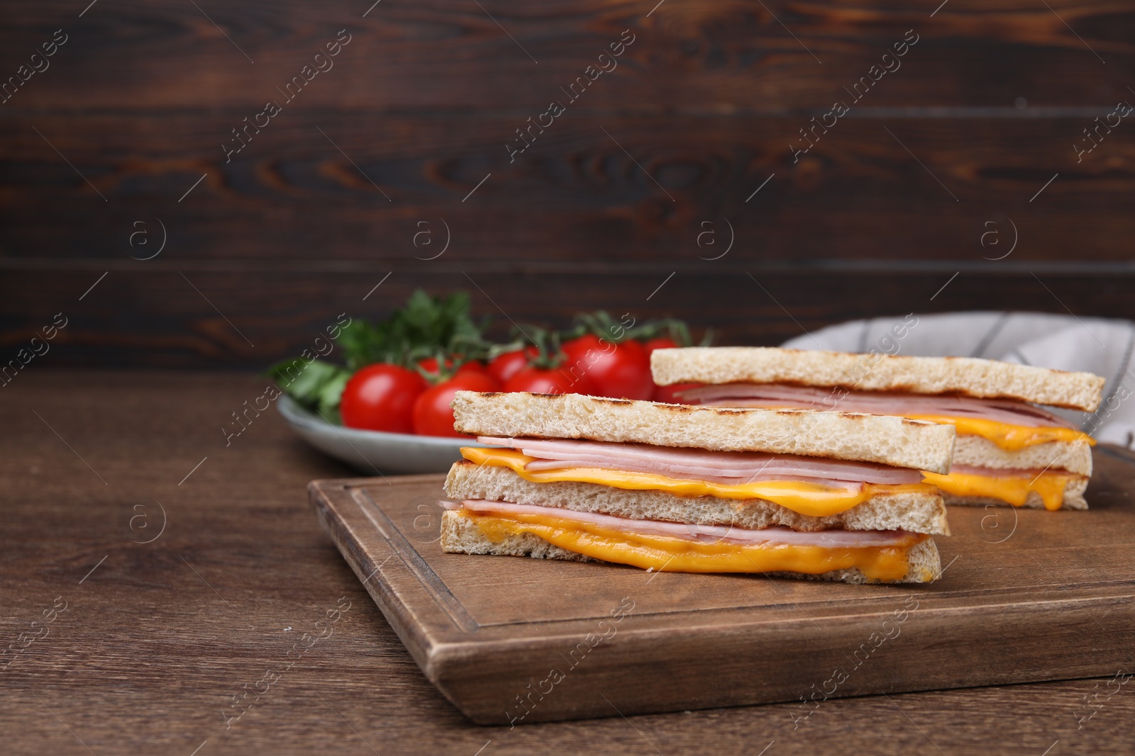 Delicious grilled sandwiches with ham and cheese on wooden table. Space for text Photo of Delicious grilled sandwiches with ham and cheese on wooden table. Space for text