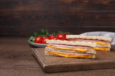 Photo of Delicious grilled sandwiches with ham and cheese on wooden table. Space for text