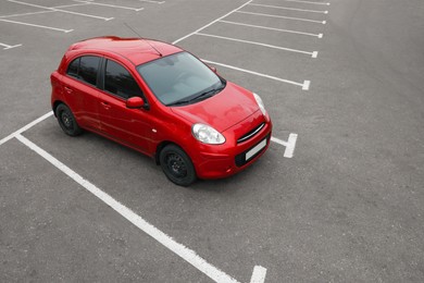 Photo of Modern red car on parking lot outdoors