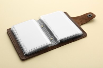 Leather business card holder with blank cards on beige background