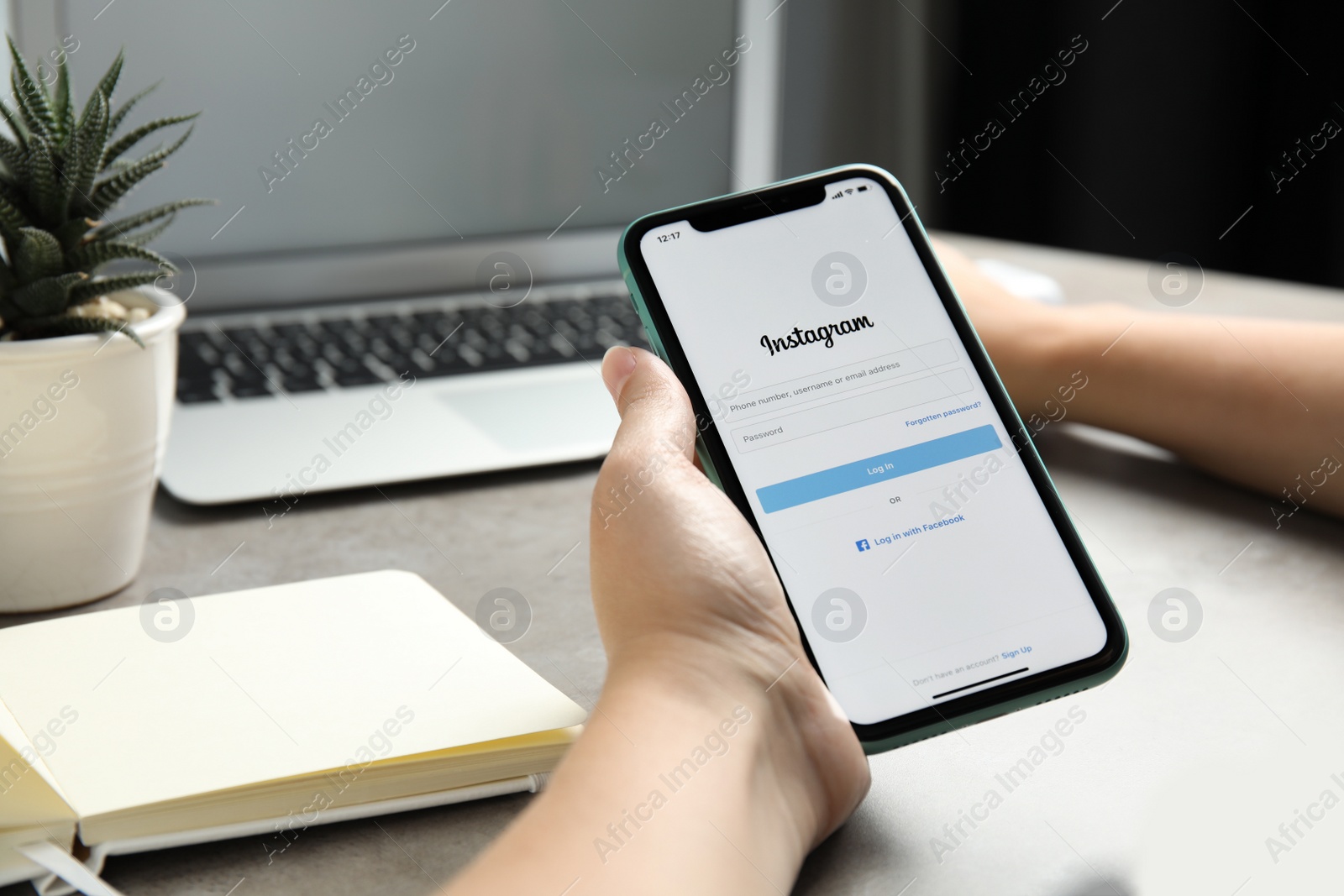 Photo of MYKOLAIV, UKRAINE - JULY 9, 2020: Woman holding Iphone 11 with Instagram app on screen at table, closeup