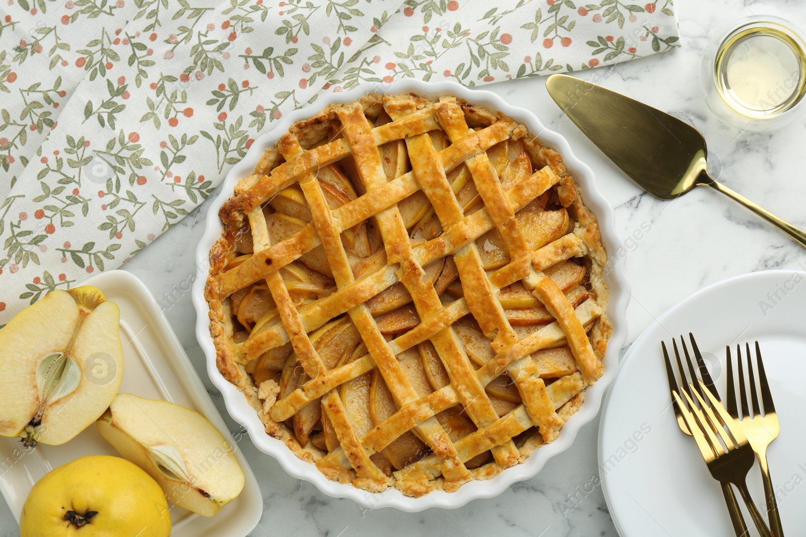 Photo of Tasty homemade quince pie served on white marble table, flat lay