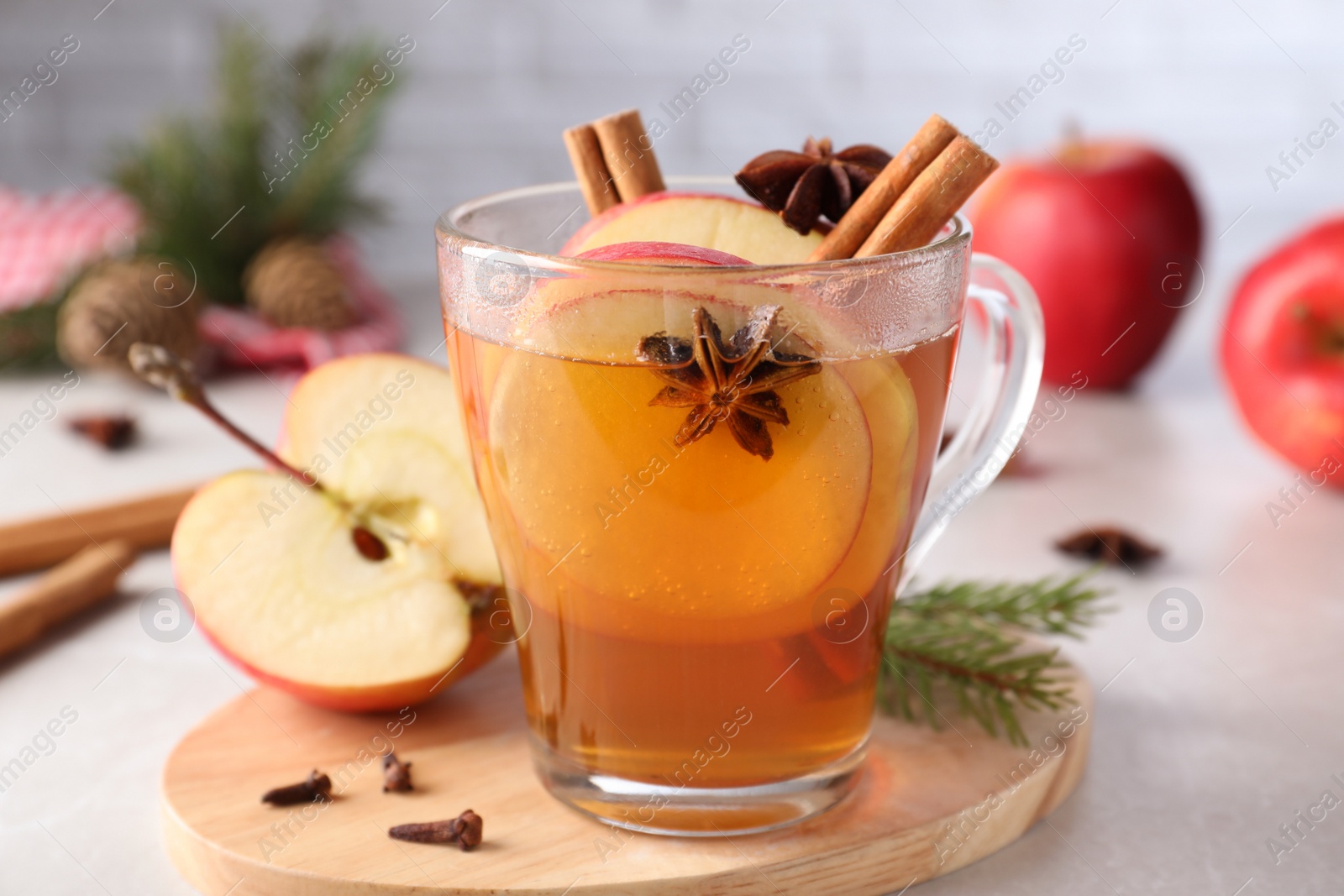 Photo of Aromatic hot mulled cider on light grey marble table