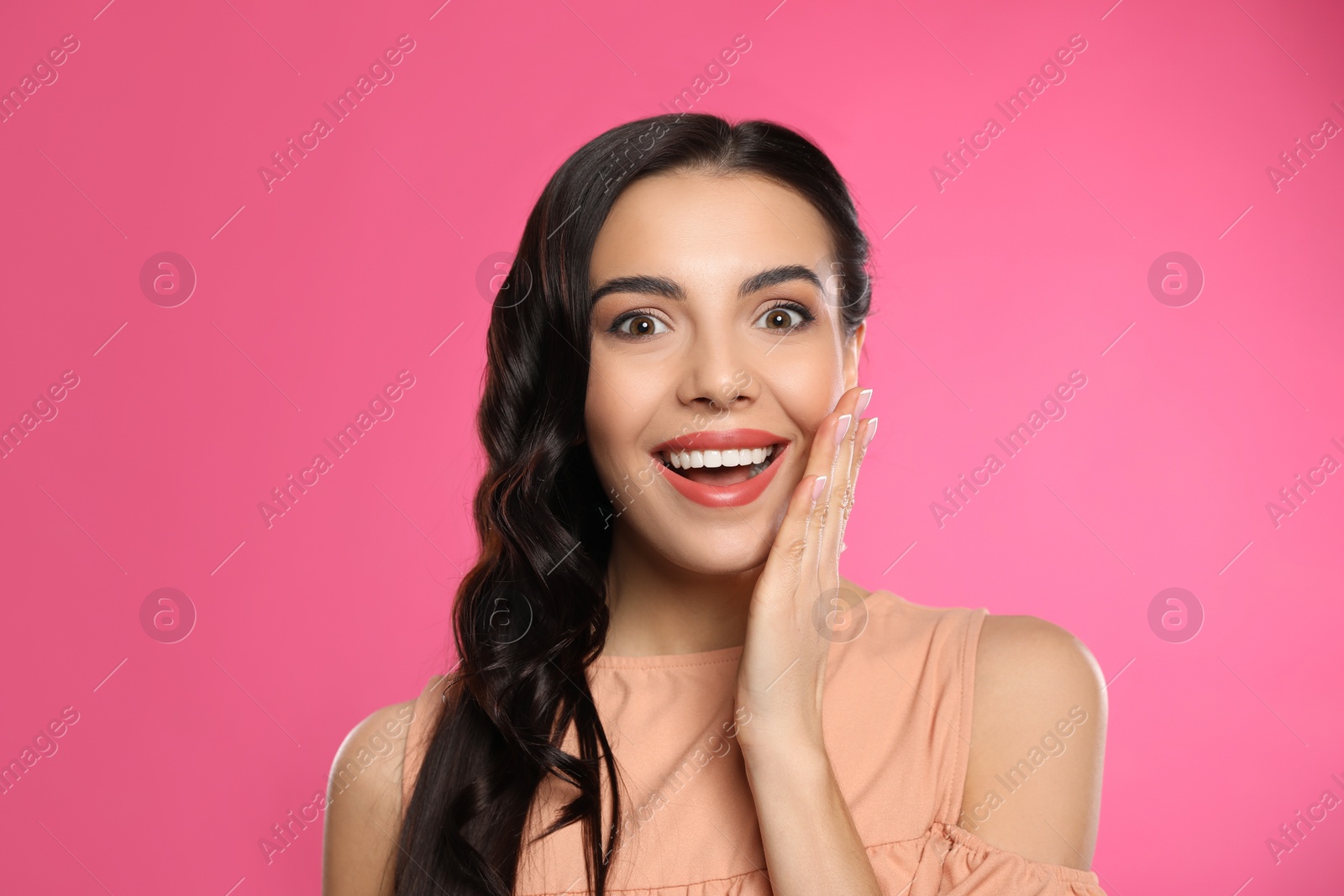 Photo of Portrait of surprised woman on pink background