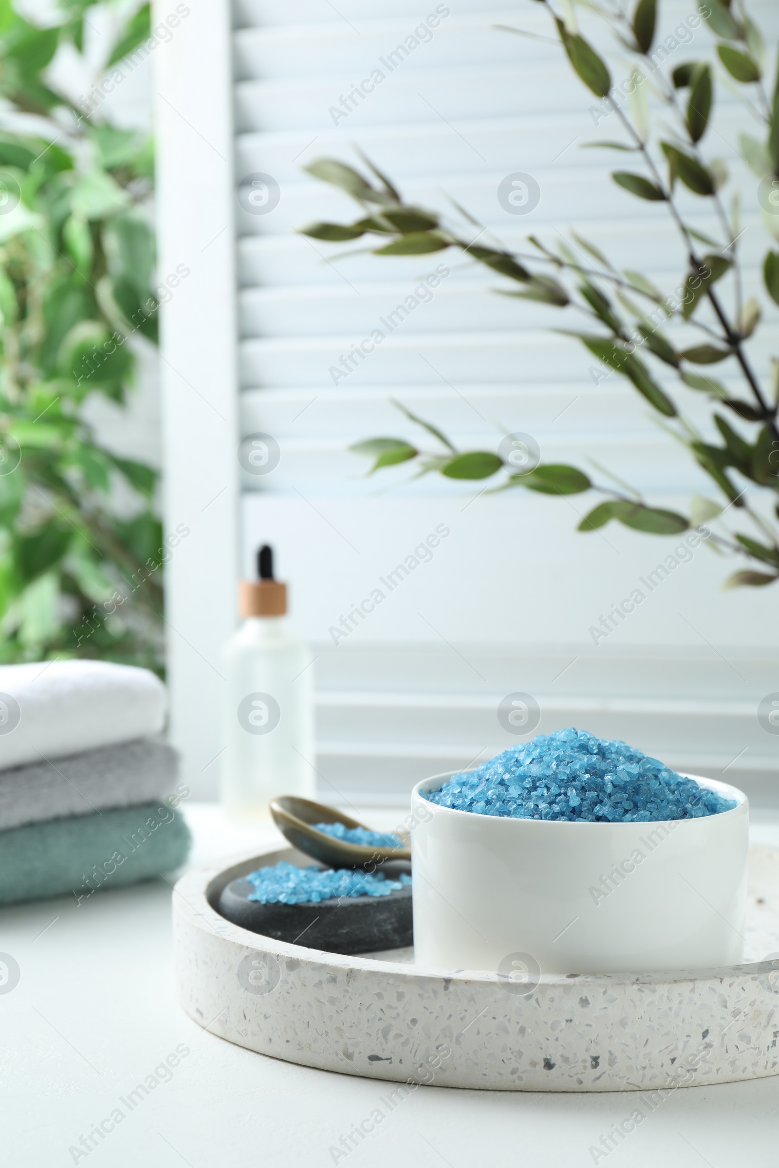 Photo of Blue sea salt on white table indoors, space for text