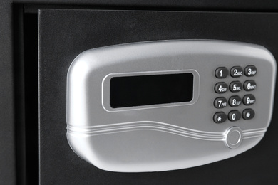 Photo of Open black steel safe with electronic lock, closeup
