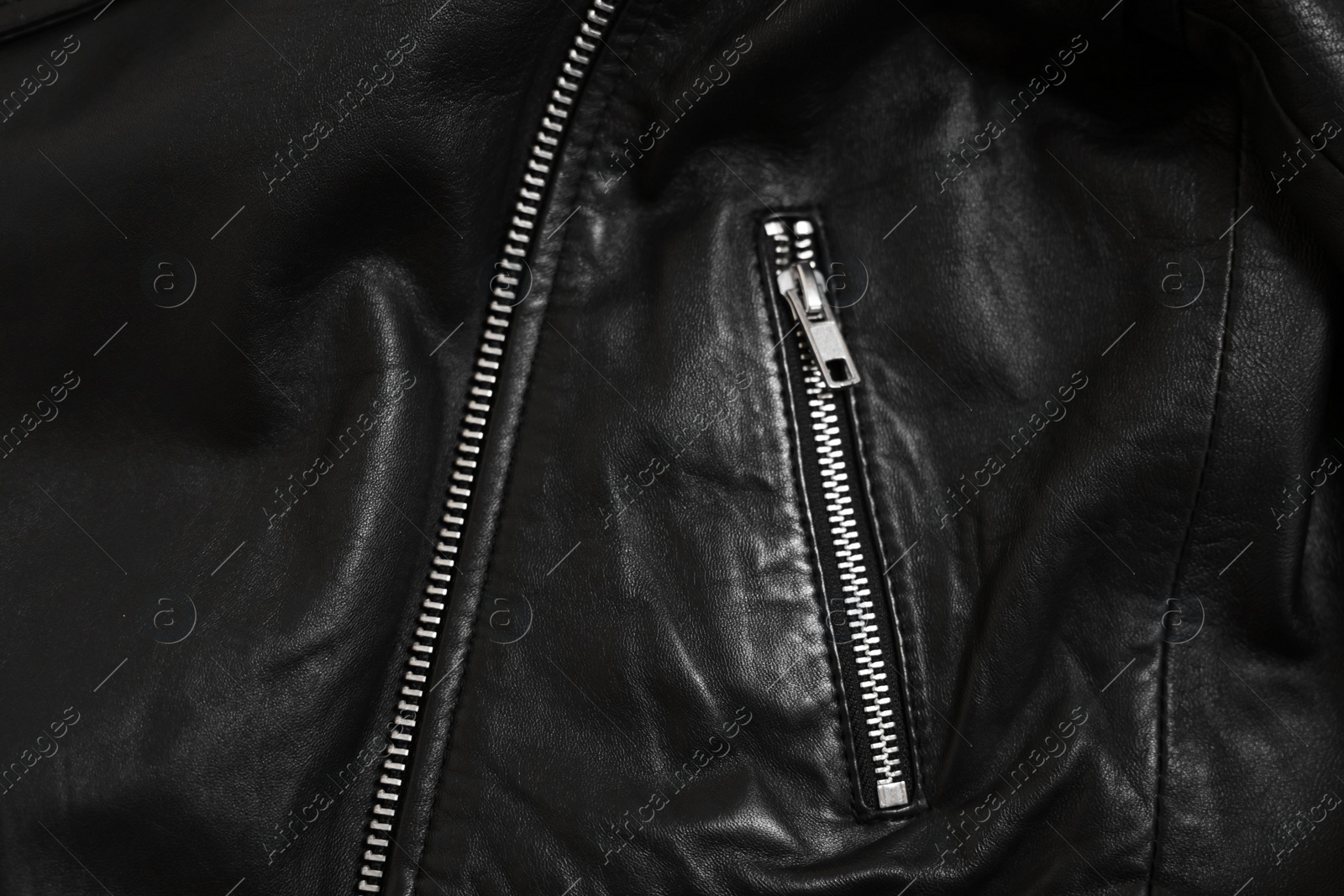 Photo of Texture of black leather jacket with zipper as background, top view