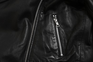 Photo of Texture of black leather jacket with zipper as background, top view