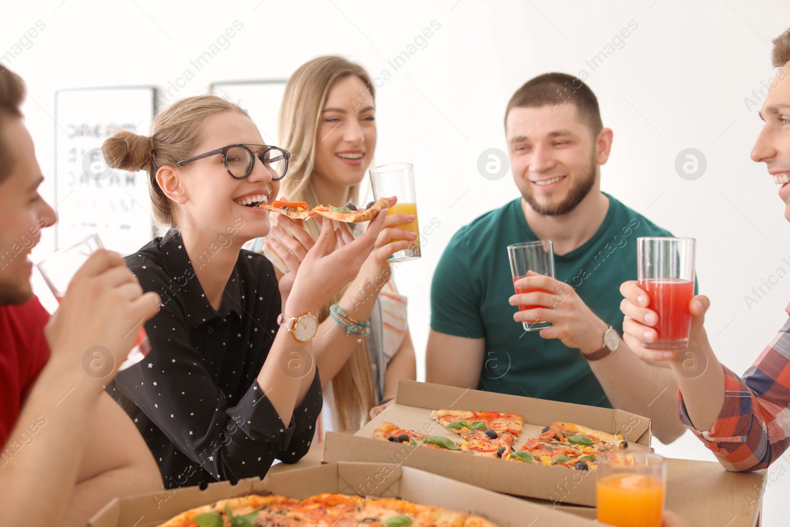 Photo of Young people having fun party with delicious pizza indoors