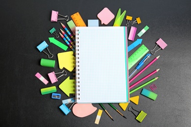 Flat lay composition with different school stationery on chalkboard surface