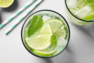 Refreshing beverage with mint and lime in glasses on table, top view