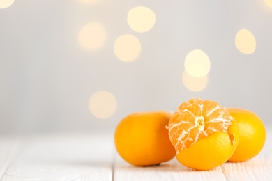 Photo of Tangerines on white table against blurred lights