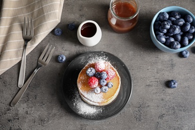 Photo of Flat lay composition with tasty pancakes and berries on table