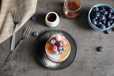 Flat lay composition with tasty pancakes and berries on table