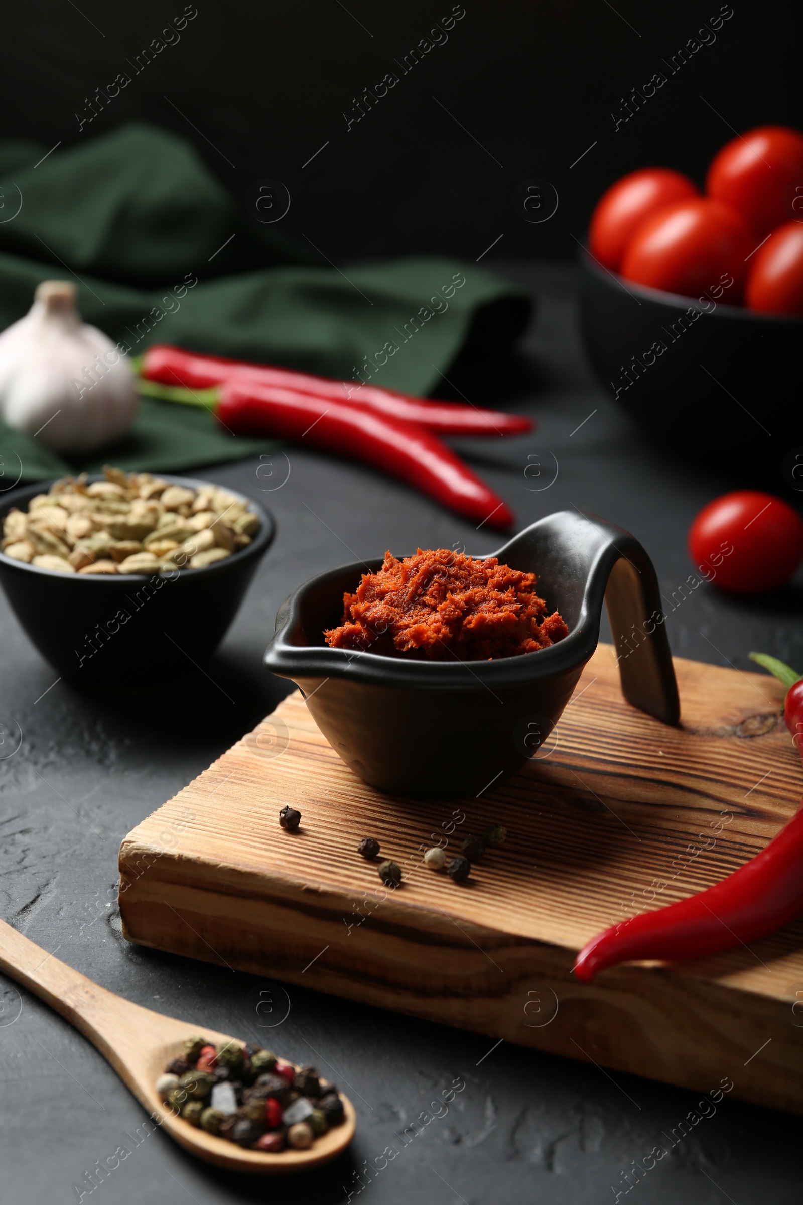 Photo of Dish with red curry paste and ingredients on black table