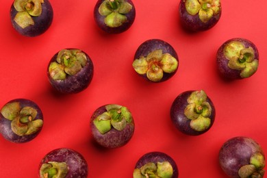 Fresh ripe mangosteen fruits on red background, flat lay