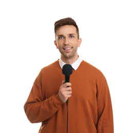 Young male journalist with microphone on white background