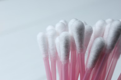 Photo of Many cotton buds on white background, closeup. Space for text