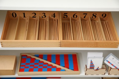 White shelving unit with different montessori toys