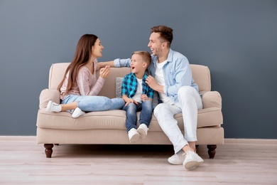 Photo of Happy family sitting on sofa, indoors