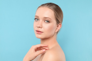 Portrait of young woman with beautiful face on blue background