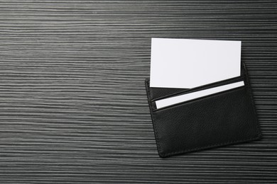 Photo of Leather business card holder with blank cards on grey table, top view. Space for text