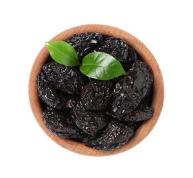 Photo of Wooden bowl with sweet dried prunes and green leaves isolated on white, top view