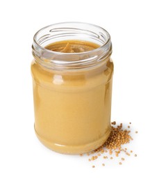Photo of Glass jar of tasty mustard sauce and dry seeds isolated on white