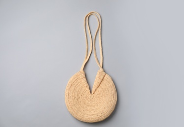 Photo of Stylish straw bag on grey background, top view. Summer accessory