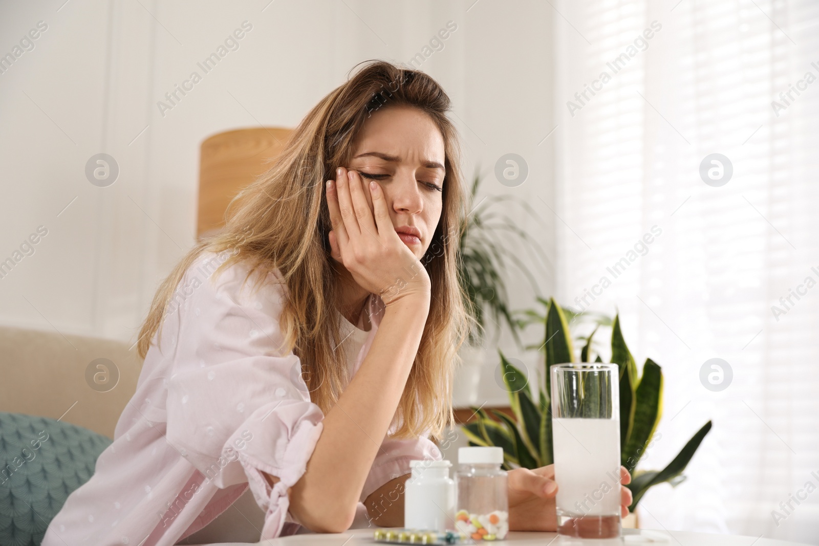 Photo of Woman holding glass of medicine for hangover at home