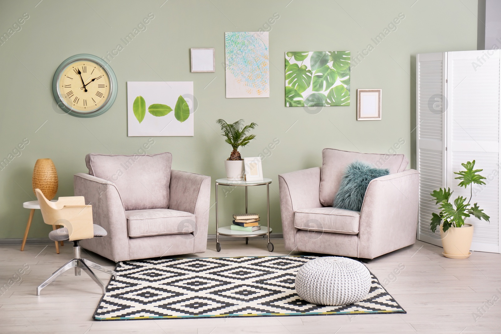 Photo of Tropical plants with green leaves and comfortable armchairs in room interior