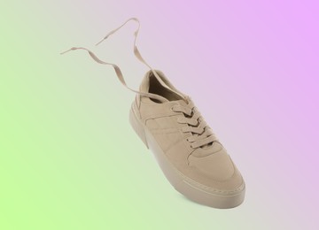 Image of One stylish sneaker in air on color gradient background