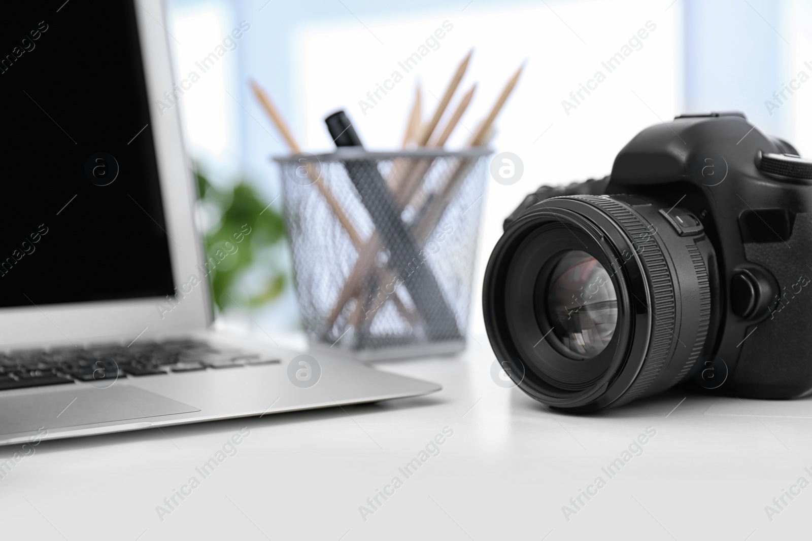 Photo of Digital camera on white table. Equipment for professional photographer