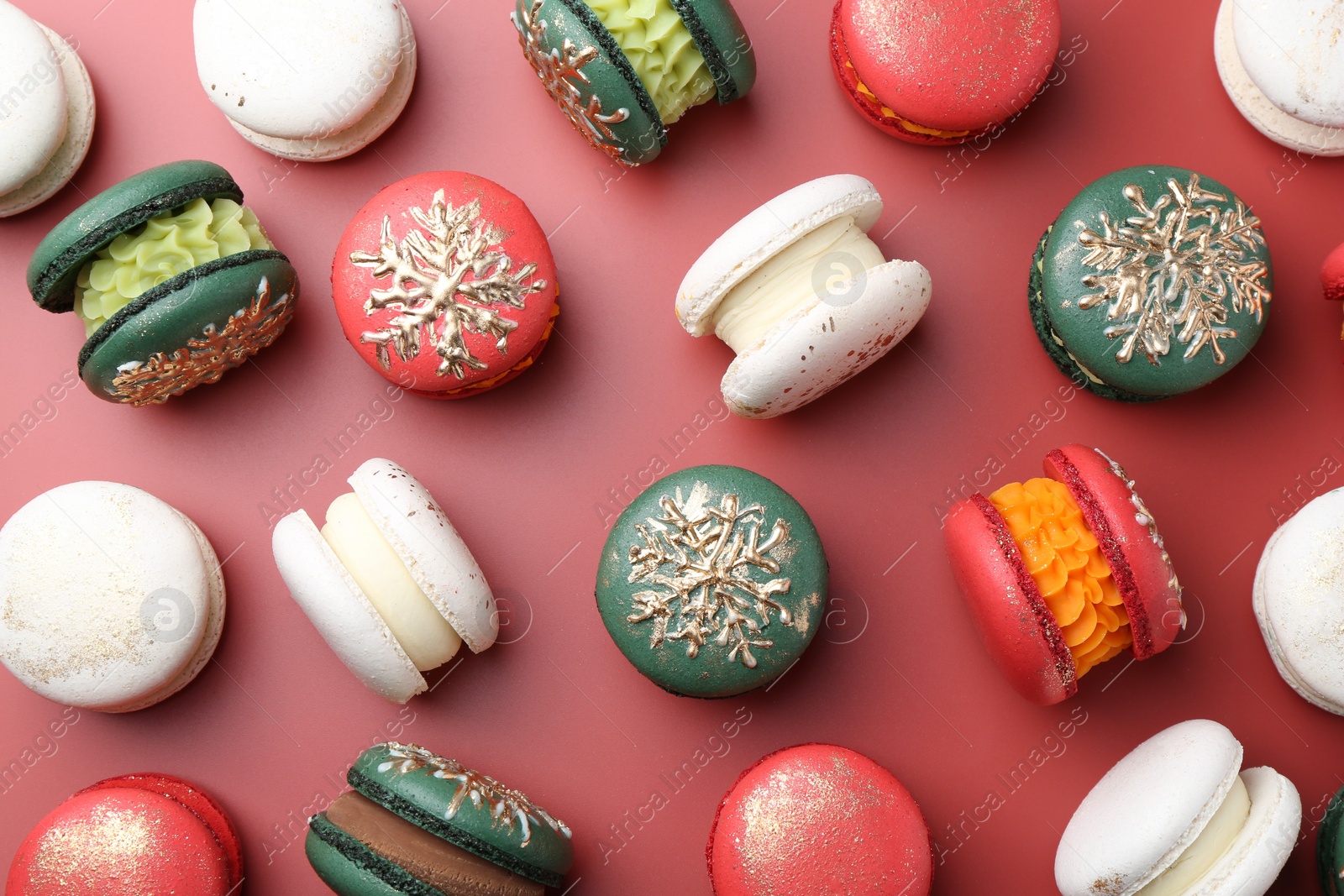 Photo of Beautifully decorated Christmas macarons on red background, flat lay